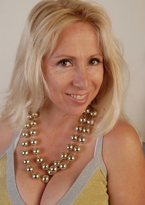 Big busted mature blonde on high heels taking off her dress and lingerie